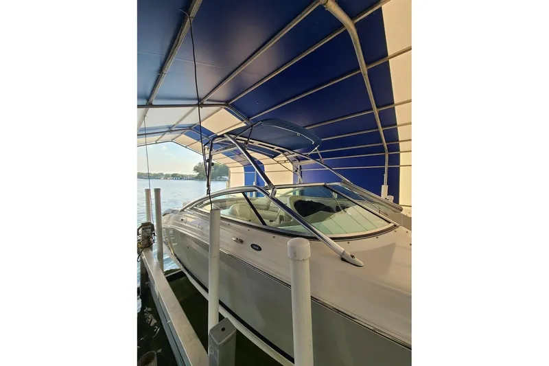 Slide: The Image of 2009 Bryant 268 boat docked under blue canopy on a sunny day. - 7