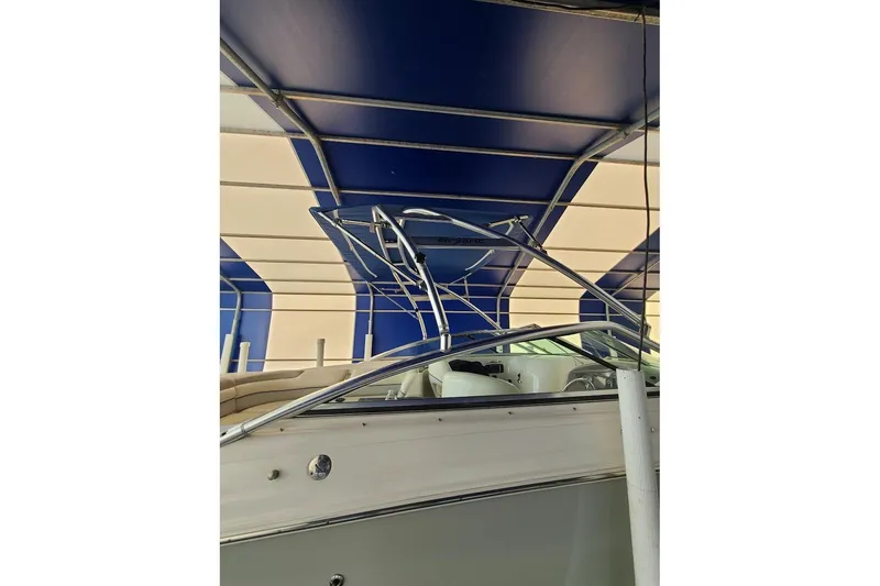 Slide: The Image of 2009 Bryant 268 boat under blue and white canopy, showcasing sleek design and seating area. - 8