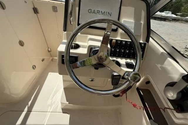 Slide: The Image of 2017 Grady-White Freedom 235 boat helm with Garmin navigation system and steering wheel. - 15
