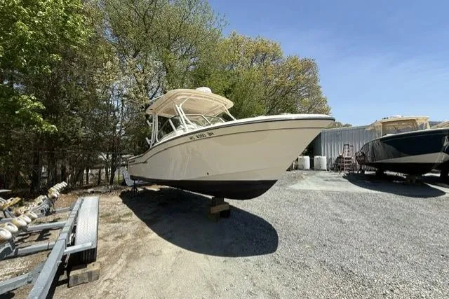 Slide: The Image of 2017 Grady-White Freedom 235 boat on display outdoors, surrounded by trees and other boats. - 2