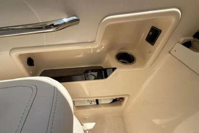 Slide: The Image of Interior detail of a 2017 Grady-White Freedom 235 boat, featuring a cup holder and storage compartment. - 21