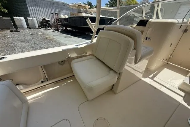 Slide: The Image of 2017 Grady-White Freedom 235 boat interior with white seating and helm station. - 23