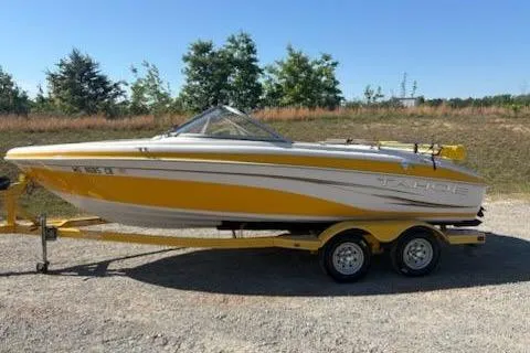 The Image of 2008 Tahoe Q6 Sport boat in yellow and white on a trailer, parked outdoors. - 1