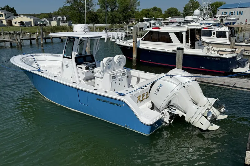 Slide: The Image of 2024 Sportsman Open 262 Center Console boat docked in a marina, featuring twin Yamaha engines. - 10