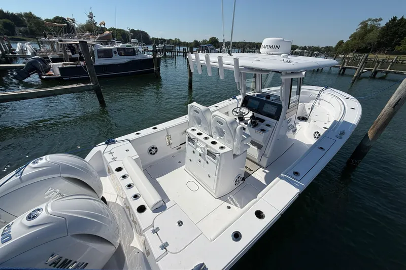 Slide: The Image of 2024 Sportsman Open 262 Center Console boat docked in a marina, featuring dual Yamaha engines. - 13