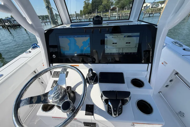 Slide: The Image of 2024 Sportsman Open 262 Center Console dashboard with dual screens and steering wheel. - 24