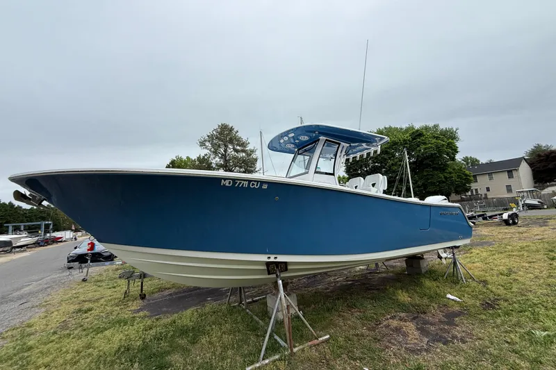 Slide: The Image of 2024 Sportsman Open 262 Center Console boat on stands, blue hull, outdoor setting. - 3