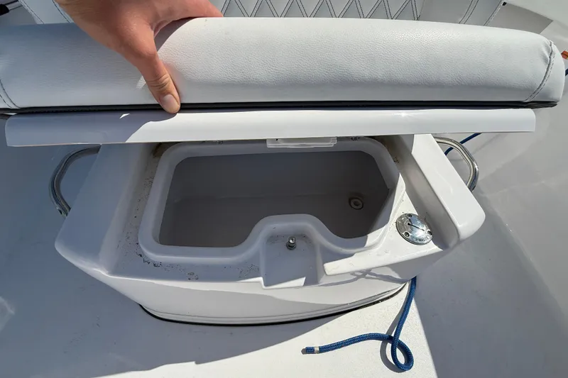 Slide: The Image of 2024 Sportsman Open 262 Center Console boat storage compartment with cushioned seat. - 30