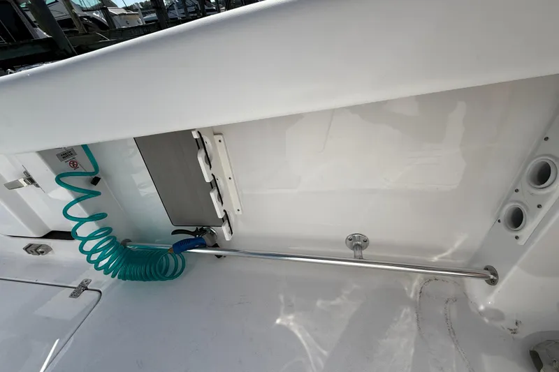 Slide: The Image of 2024 Sportsman Open 262 Center Console boat interior with coiled hose and storage features. - 31