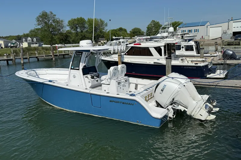 Slide: The Image of 2024 Sportsman Open 262 Center Console boat docked in a marina, featuring dual Yamaha engines. - 36