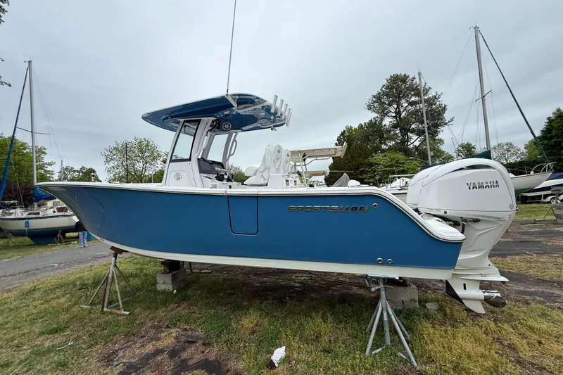 Slide: The Image of 2024 Sportsman Open 262 Center Console boat with Yamaha engine, displayed on stands outdoors. - 4