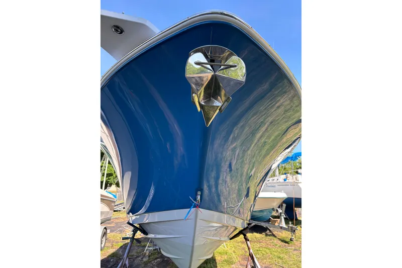 Slide: The Image of 2024 Sportsman Open 262 Center Console boat with sleek blue hull, viewed from the front. - 5