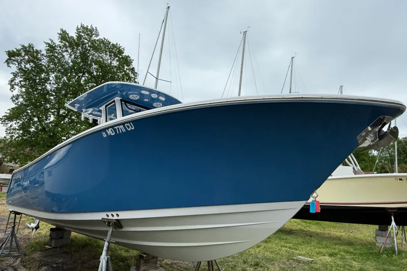 Slide: The Image of 2024 Sportsman Open 262 Center Console boat in blue, displayed outdoors. - 6