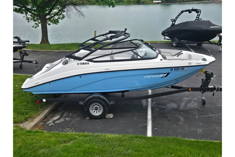 The Image of 2025 Yamaha Boats AR190 on trailer by a lake, showcasing sleek design and blue hull. - 0
