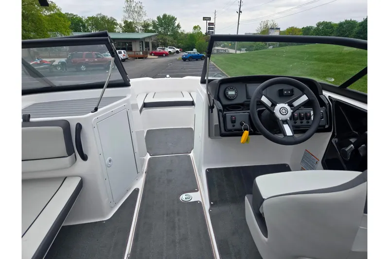 Slide: The Image of 2025 Yamaha Boats AR190 interior with steering wheel, dashboard, and seating in a parking lot setting. - 12