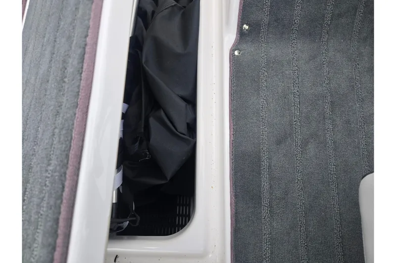 Slide: The Image of 2025 Yamaha AR190 boat interior storage compartment with carpeted flooring. - 13
