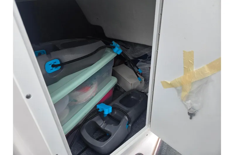 Slide: The Image of Storage compartment in a 2025 Yamaha Boats AR190, featuring organized containers and equipment. - 14