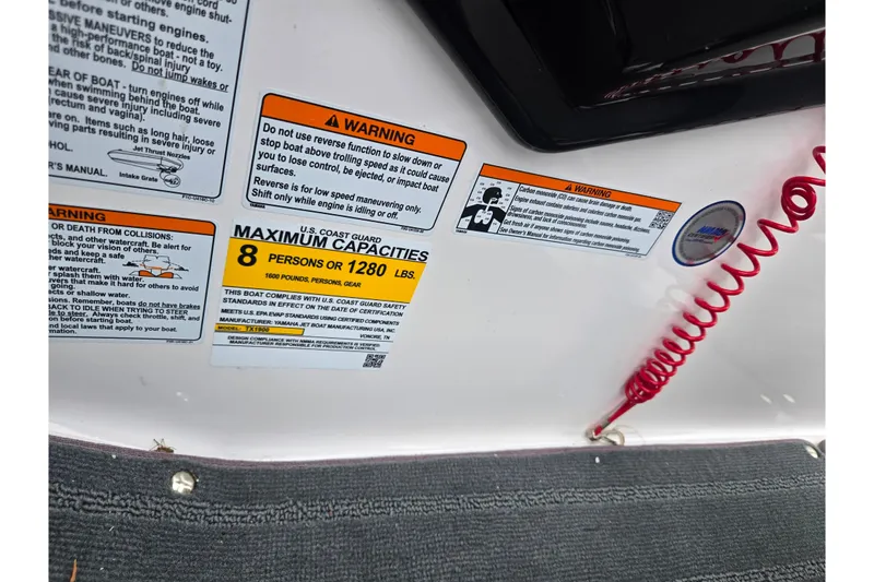 Slide: The Image of Warning labels and capacity information on a 2025 Yamaha Boats AR190. - 16
