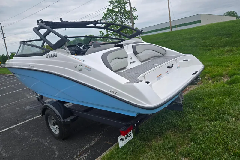 Slide: The Image of 2025 Yamaha Boats AR190 on trailer, blue and white design, parked on grass. - 3