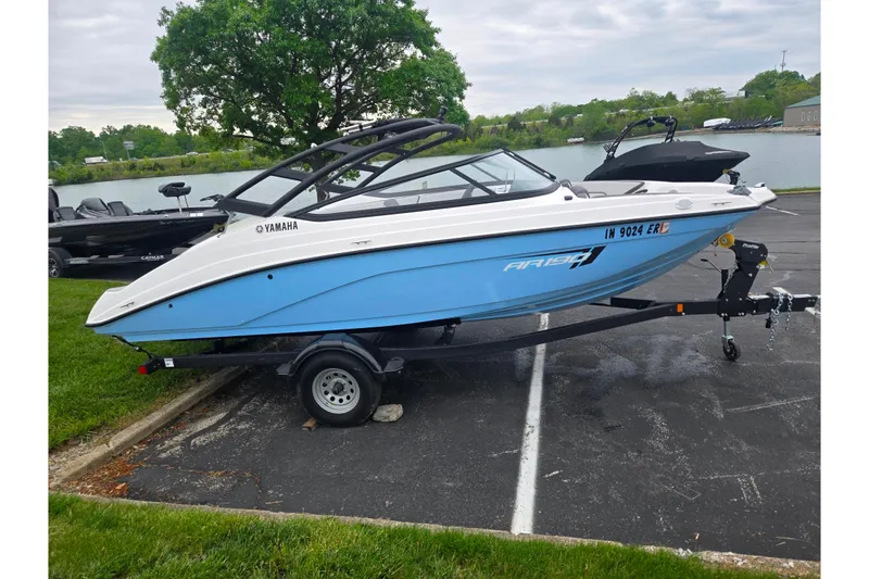 Slide: The Image of 2025 Yamaha AR190 boat on trailer by a lakeside parking area. - 9