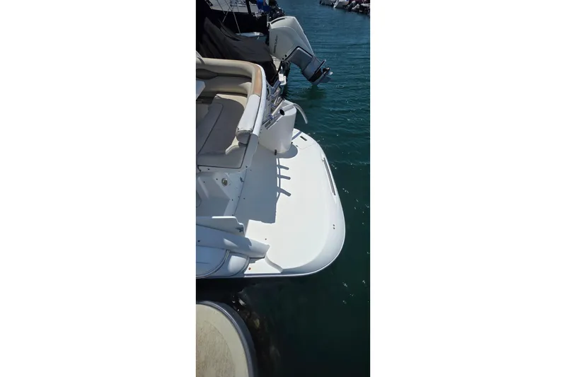 Slide: The Image of 2001 Doral 250se boat stern view with seating and outboard motor in marina. - 18
