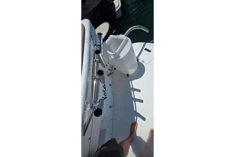 Slide: The Image of 2001 Doral 250se boat deck with rod holders and a white seat. - 19