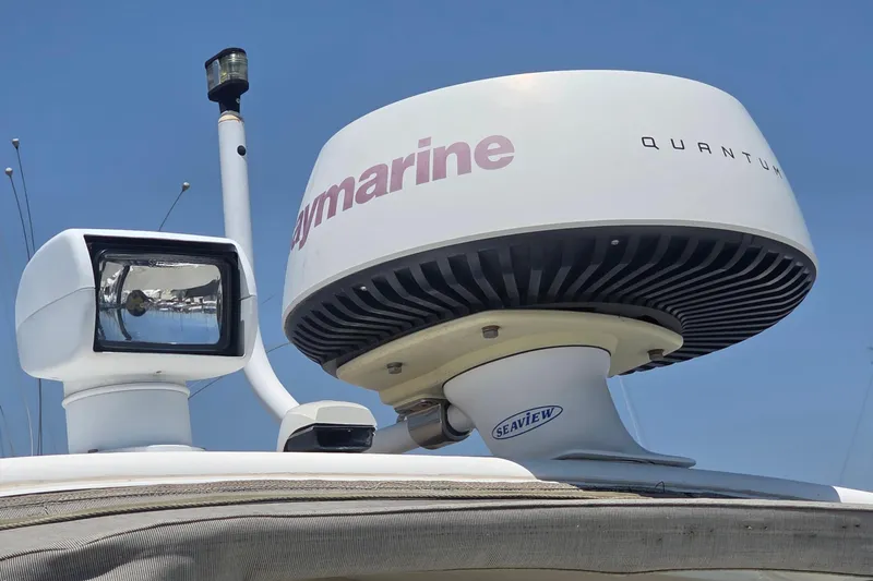 Slide: The Image of Radar and spotlight on a 2001 Doral 250se boat under clear blue sky. - 20