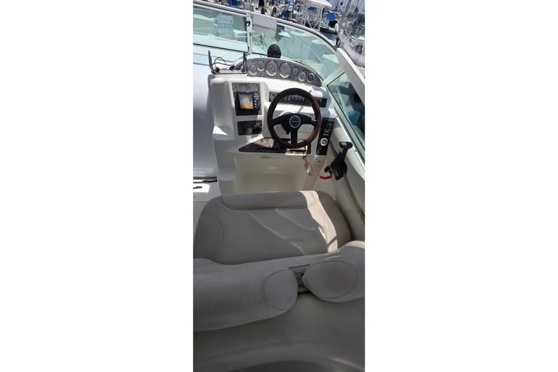 Slide: The Image of Interior view of a 2001 Doral 250se boat cockpit with steering wheel and controls. - 7