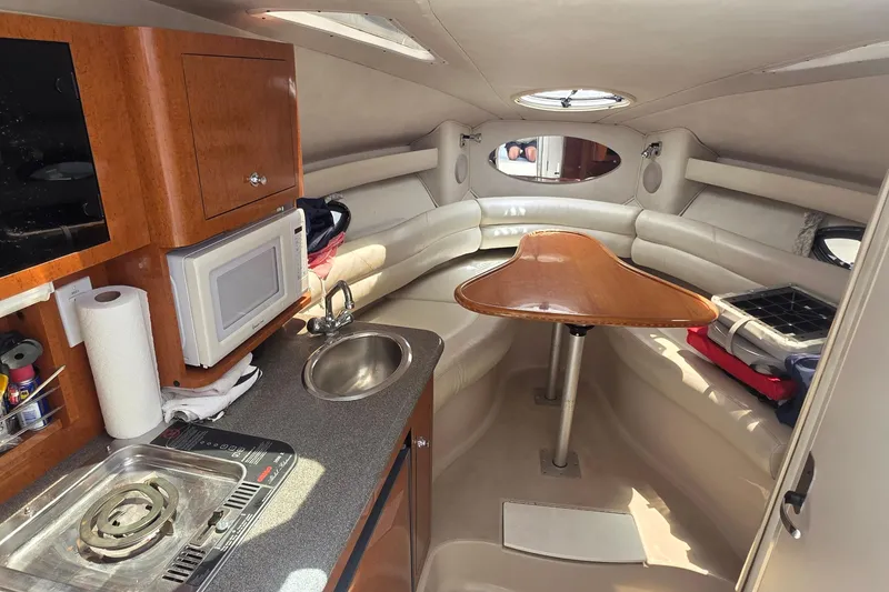 Slide: The Image of Interior of a 2001 Doral 250se boat with kitchenette and seating area. - 9