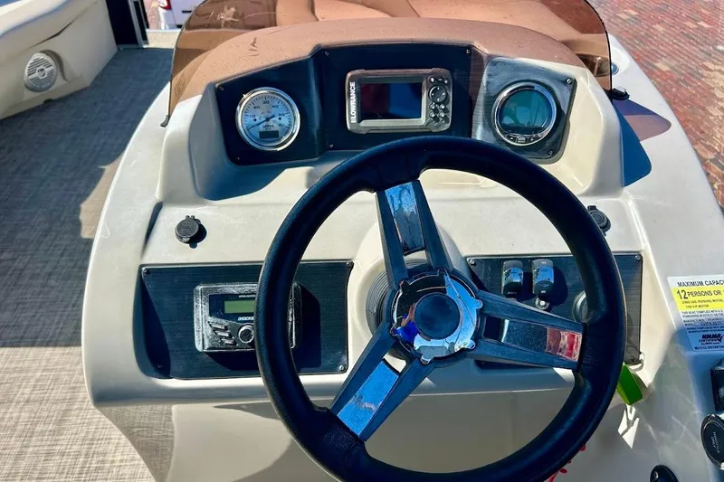 Slide: The Image of 2023 Cypress Cay Seabreeze 232 boat dashboard with steering wheel and gauges. - 13
