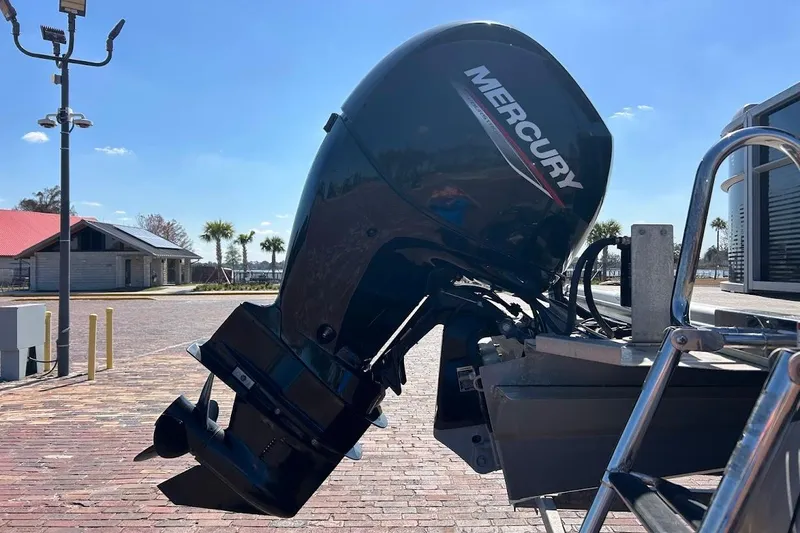 Slide: The Image of 2023 Cypress Cay Seabreeze 232 with Mercury outboard motor in a sunny marina setting. - 7