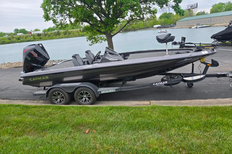 Slide: The Image of 2022 Caymas CX 19 boat on trailer by a lakeside, showcasing sleek design and powerful engine. - 11