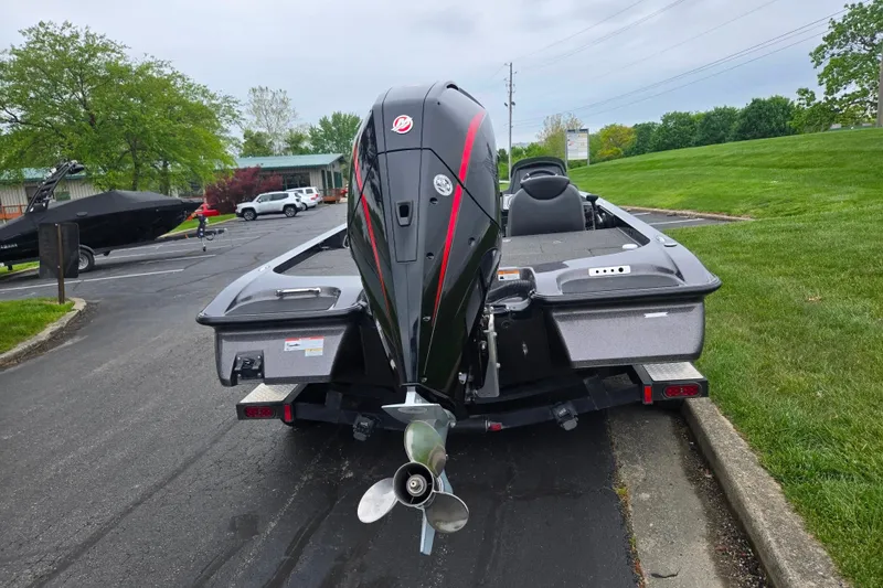 Slide: The Image of 2022 Caymas CX 19 boat on trailer, rear view with outboard motor, parked on asphalt. - 2