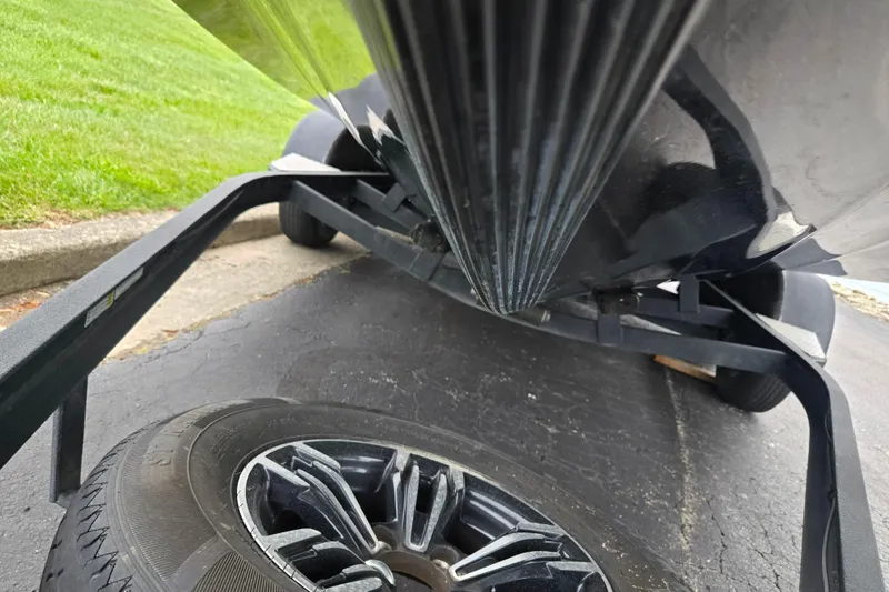 Slide: The Image of 2022 Caymas CX 19 boat on trailer, close-up of hull and wheel, parked on pavement. - 7