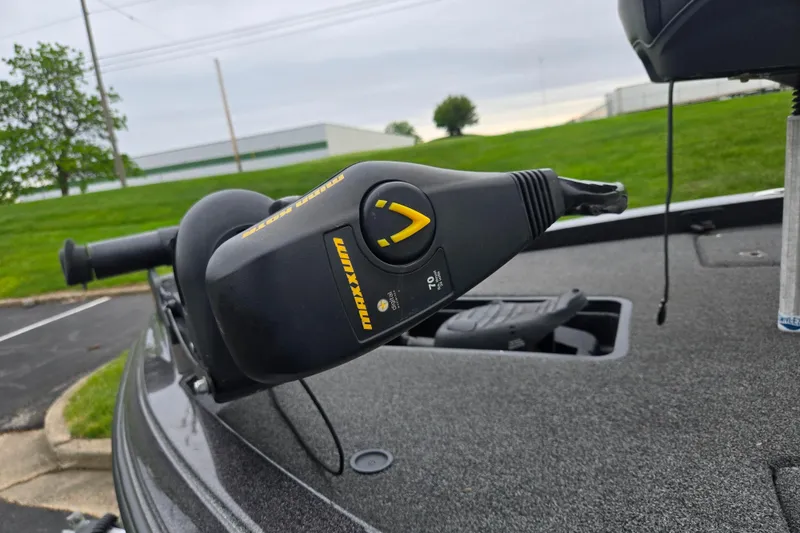Slide: The Image of Trolling motor on 2022 Caymas CX 19 boat, parked on asphalt with green grass background. - 9