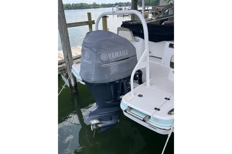 Slide: The Image of 2019 Chaparral 250 Suncoast with Yamaha outboard motor, docked on a serene lake. - 18
