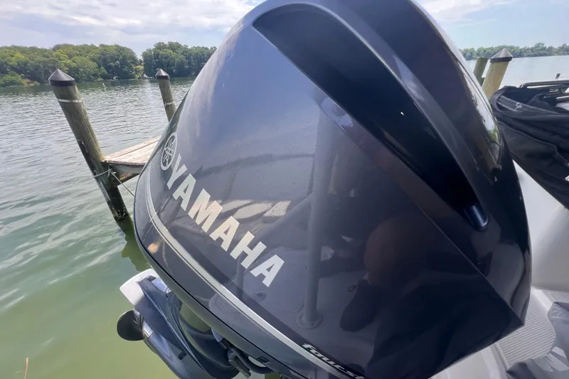Slide: The Image of Yamaha outboard motor on a 2019 Chaparral 250 Suncoast, docked by a serene lake. - 22