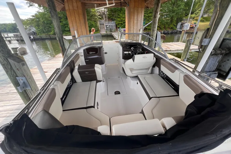 Slide: The Image of 2019 Chaparral 250 Suncoast boat interior with seating and steering wheel at dock. - 23