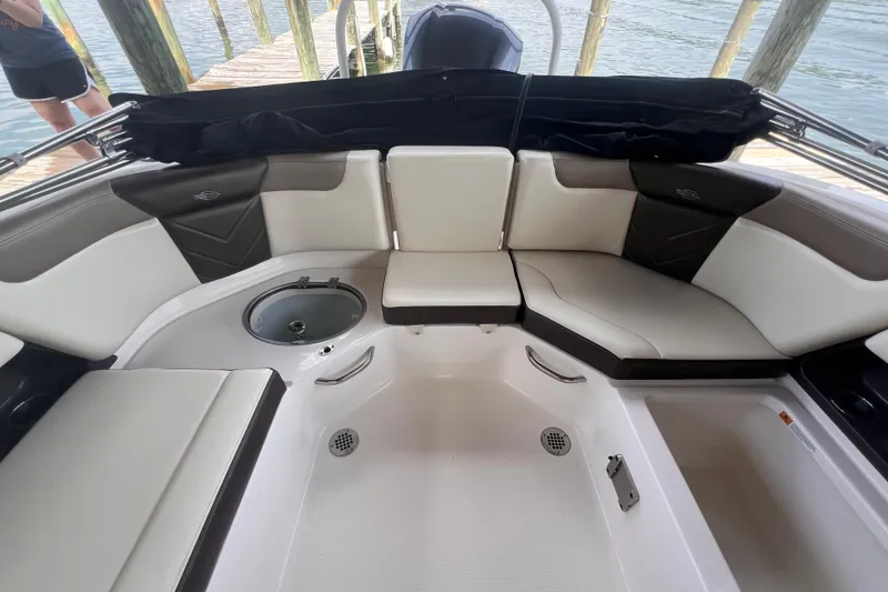 Slide: The Image of 2019 Chaparral 250 Suncoast boat interior with cushioned seating and storage compartments. - 24