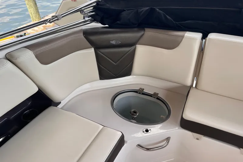 Slide: The Image of 2019 Chaparral 250 Suncoast boat interior with cushioned seating and built-in storage. - 25