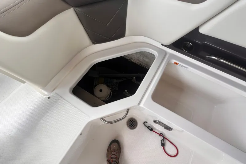Slide: The Image of 2019 Chaparral 250 Suncoast boat interior storage compartments and footwell. - 29