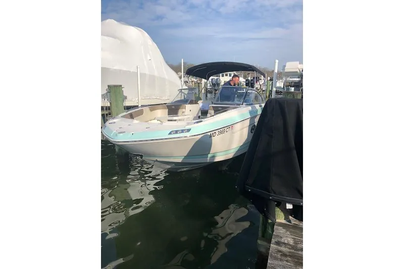 Slide: The Image of 2019 Chaparral 250 Suncoast boat docked at marina, featuring sleek design and spacious seating. - 3