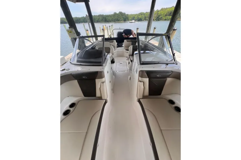 Slide: The Image of 2019 Chaparral 250 Suncoast boat interior at dock, featuring seating and windshield. - 35
