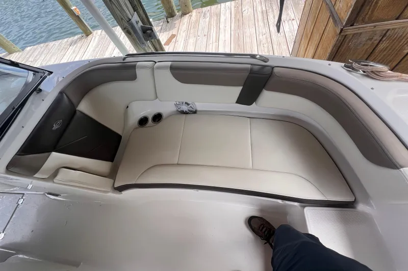 Slide: The Image of 2019 Chaparral 250 Suncoast boat interior with beige seating and cup holders. - 37