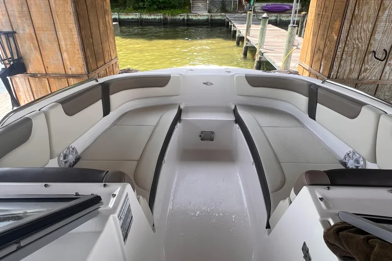Slide: The Image of 2019 Chaparral 250 Suncoast boat interior with spacious seating and dock view. - 41