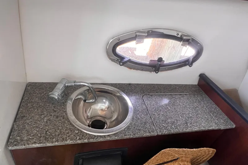 Slide: The Image of 2019 Chaparral 250 Suncoast boat interior with granite countertop and stainless steel sink. - 43