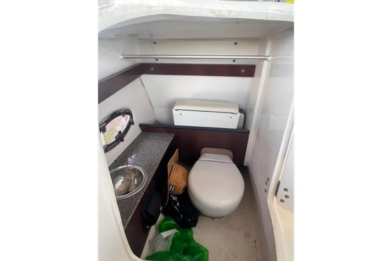 Slide: The Image of 2019 Chaparral 250 Suncoast boat interior with compact bathroom and sink. - 44
