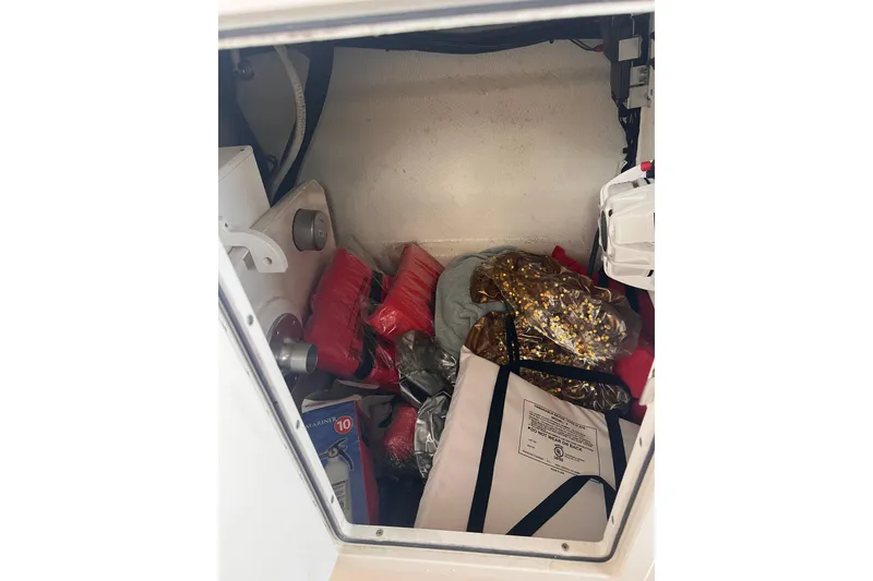 Slide: The Image of Storage compartment of 2019 Chaparral 250 Suncoast boat with various items inside. - 52