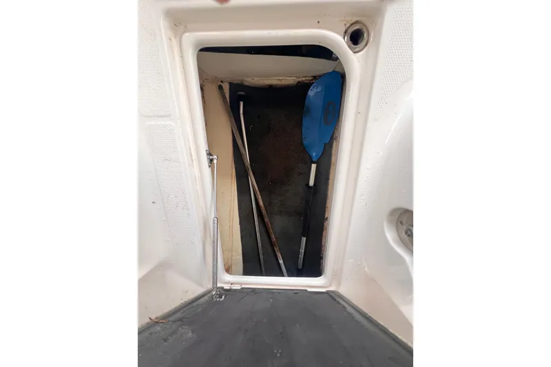 Slide: The Image of Storage compartment of 2019 Chaparral 250 Suncoast boat with paddle and equipment. - 53