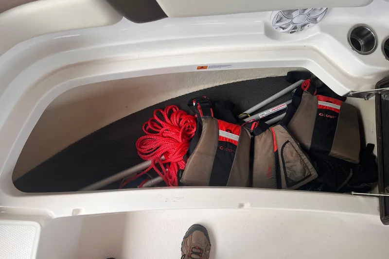 Slide: The Image of Storage compartment in a 2019 Chaparral 250 Suncoast boat with life jackets and red rope. - 54